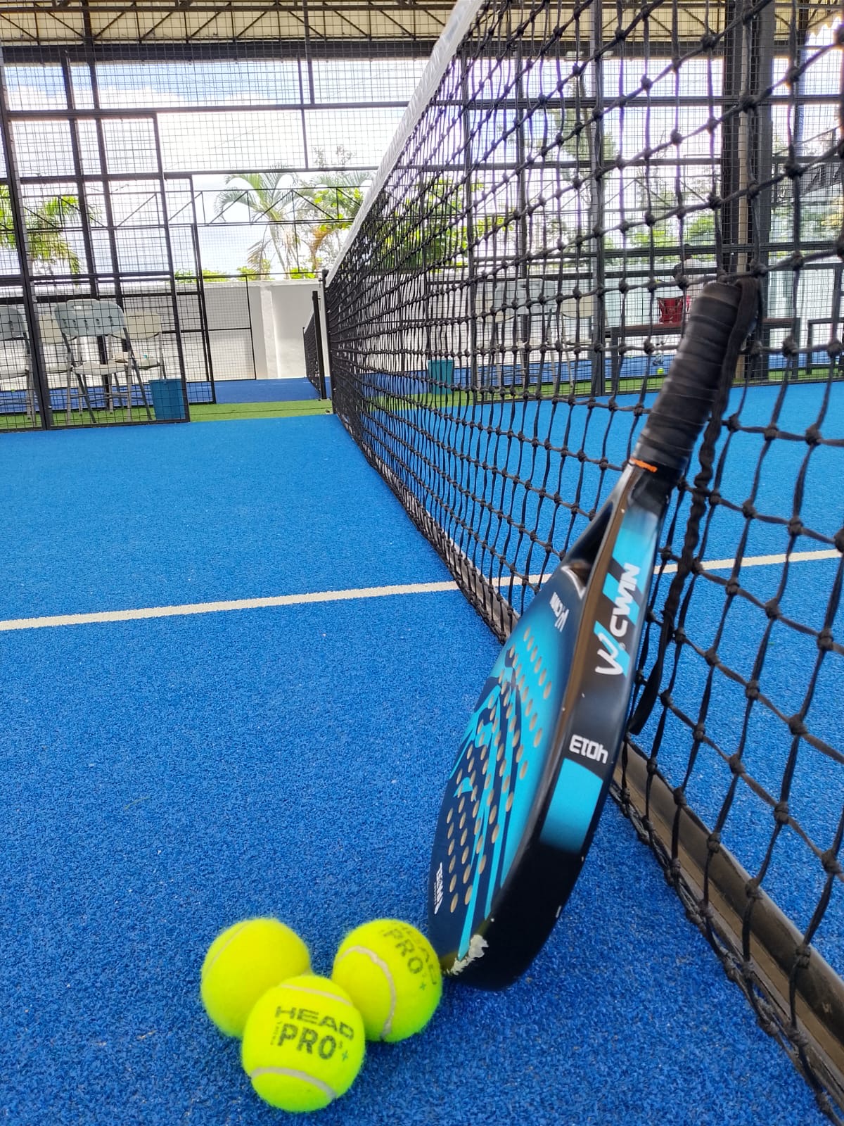 Raquette et balles de padel au filet